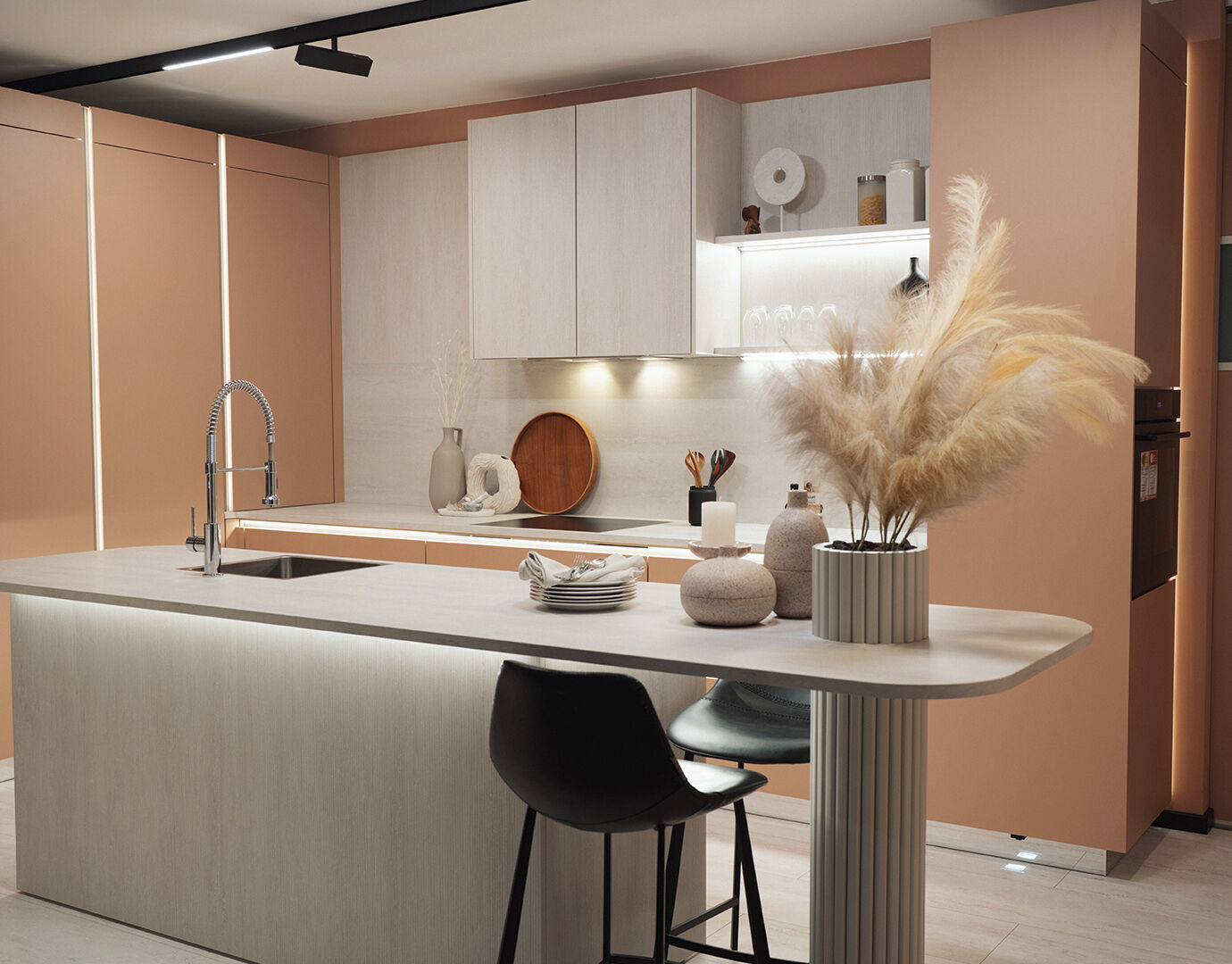 Zalmroze keuken gecombineerd met lichte accenten, led strips, een onzichtbaar gemonteerde afzuigkap 